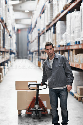 Buy stock photo A young man using a pallet truck to pack boxes in a warehouse