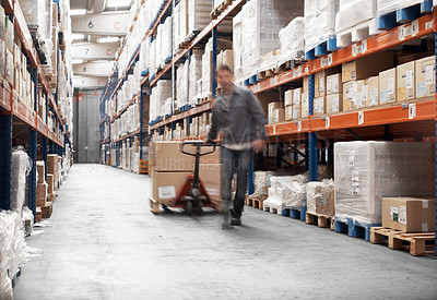 Buy stock photo A young man using a pallet truck to transport boxes in a storehouse