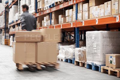 Buy stock photo A young man in a storehouse moving inventory using a pallet truck