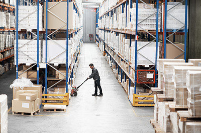 Buy stock photo A young man packing boxes in a warehouse using a pallet truck