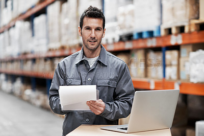 Buy stock photo Portrait of a young man working on his laptop while working in a storehouse