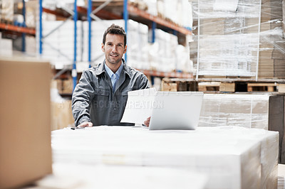 Buy stock photo Portrait of a young man working on his notebook while sitting in a warehouse