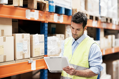 Buy stock photo A young man checking stock in a warehouse