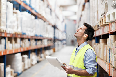 Buy stock photo A young man doing stock take in a storehouse