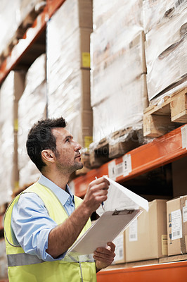 Buy stock photo A young man checking supplies in a warehouse