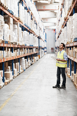 Buy stock photo A young man checking inventory in a warehouse