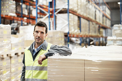 Buy stock photo Portrait of a young man leaning on some boxes in a warehouse