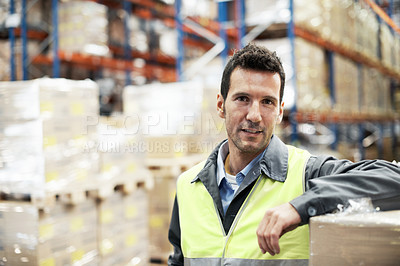 Buy stock photo Portrait of a young man leaning on some boxes in a storehouse