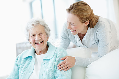 Buy stock photo Laugh, women and elderly mother in home with love, smile or family together in living room. Adult daughter, senior parent or funny joke on sofa for bonding, care or portrait with retirement story