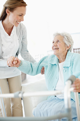 Buy stock photo Wheelchair, caregiver and old woman on sofa with helping hand, support and trust in retirement care. Smile, volunteer and senior person with disability, mobility aid or assistance in nursing home.