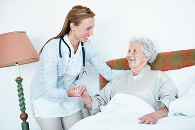 Buy stock photo Caregiver, support and senior woman in bed for homecare, healthcare and holding hands with smile. Help, happy and medical service with nurse and elderly patient in retirement at  nursing home