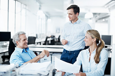 Buy stock photo Three businesspeople working together in their office