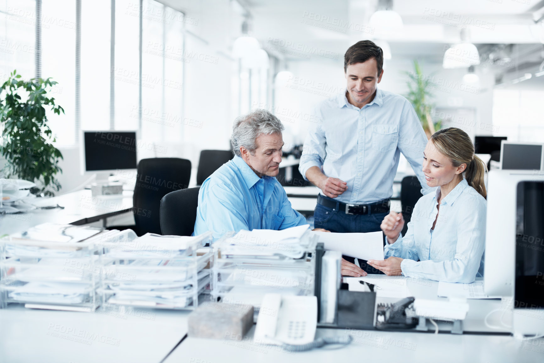 Buy stock photo Three businesspeople working together in their office