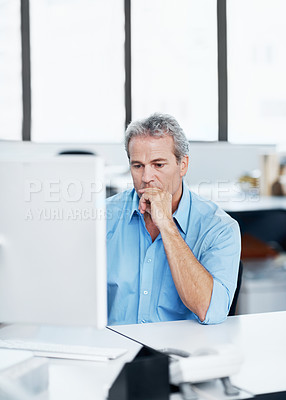 Buy stock photo A mature man looking pensive while sitting at his office desk