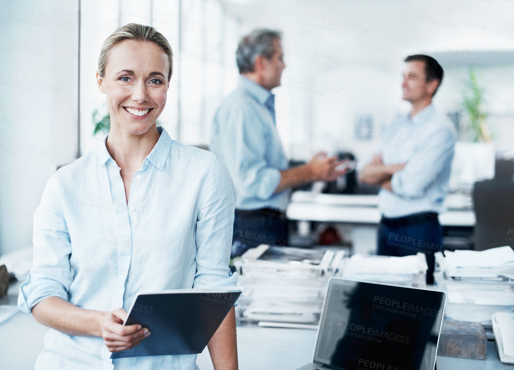 Buy stock photo Portrait of an attractive young businesswoman holding a digital tablet with her colleagues in the background