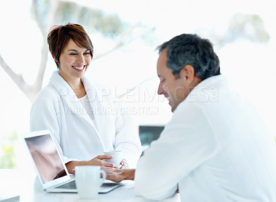 Buy stock photo Happy couple, conversation and laptop at house in morning, coffee and talking about news online. People, marriage and beverage with chat, connection and smile with tech for internet updates at home