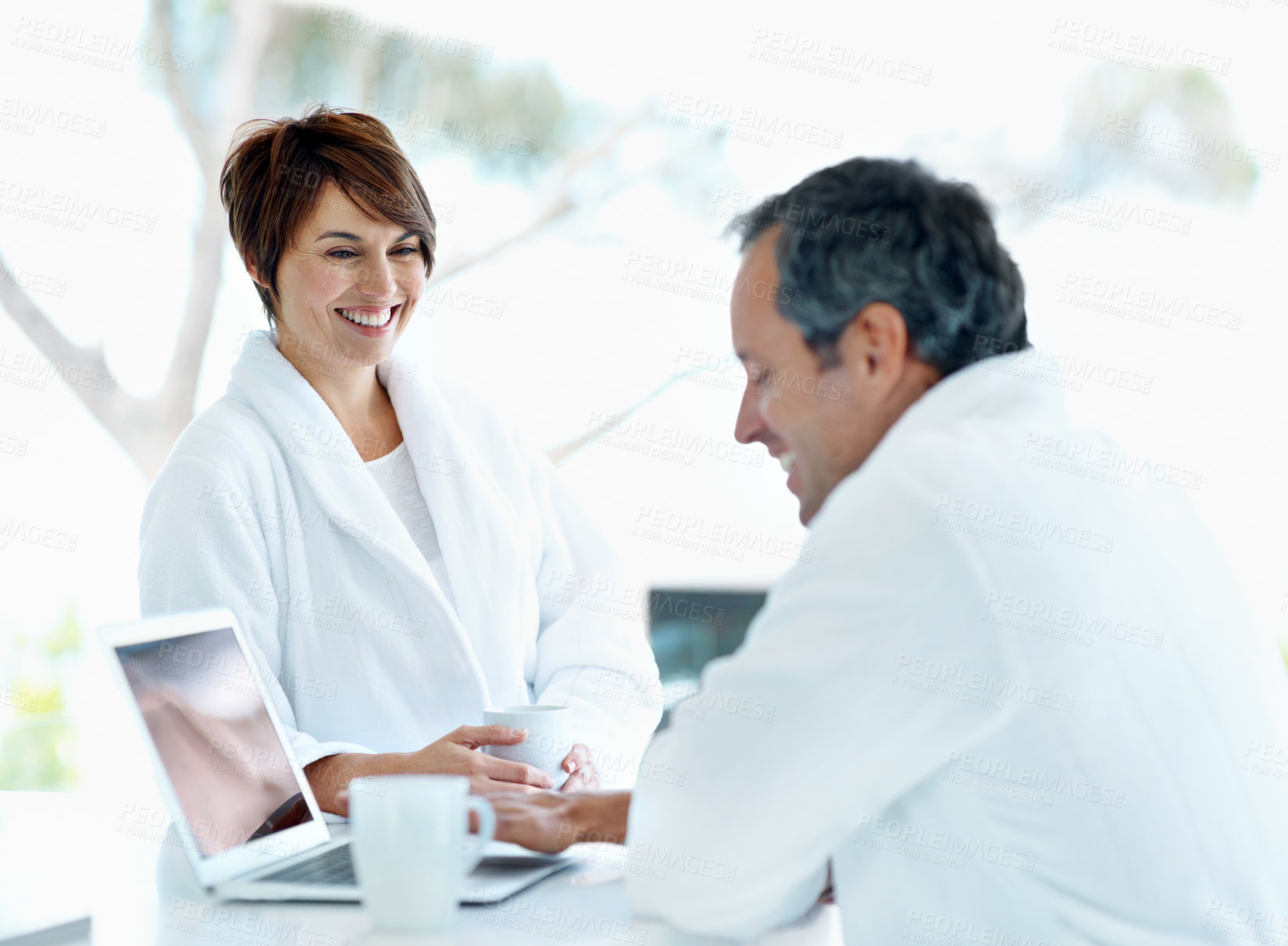 Buy stock photo Happy couple, conversation and laptop at house in morning, coffee and talking about news online. People, marriage and beverage with chat, connection and smile with tech for internet updates at home