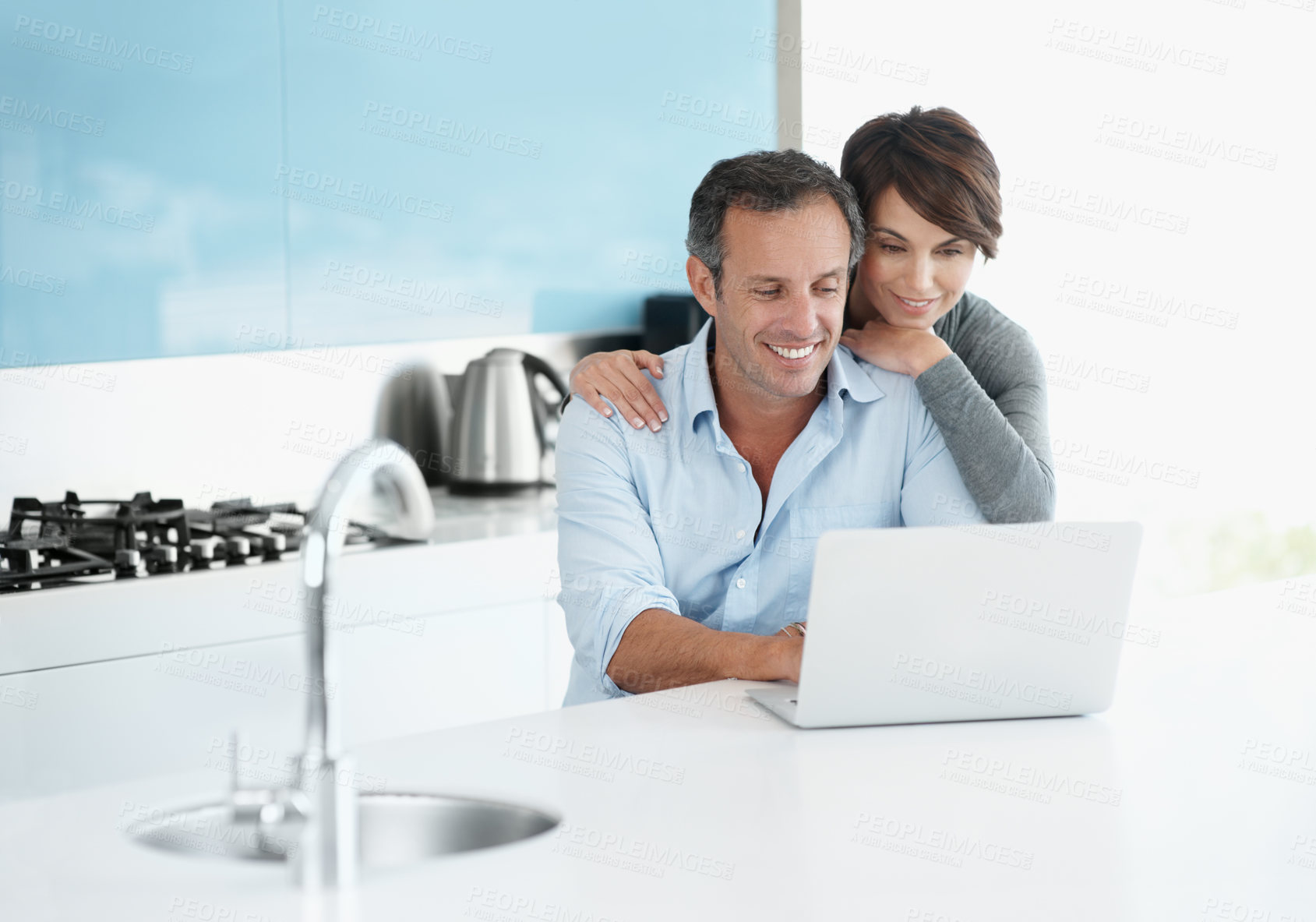 Buy stock photo Financial planning, online and happy couple with laptop in kitchen, asset management and info on web. People, hug and research with technology for budget review, space and risk assessment in house