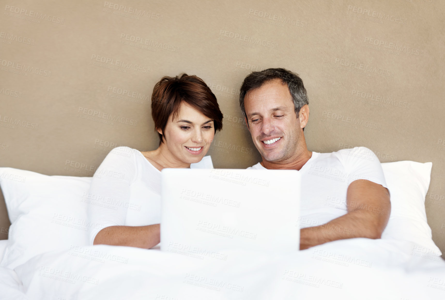 Buy stock photo Happy, laptop and couple relax on bed with love, care and bonding with comfort and web in home. Man, woman and technology in house bedroom with internet connection, streaming online and subscription