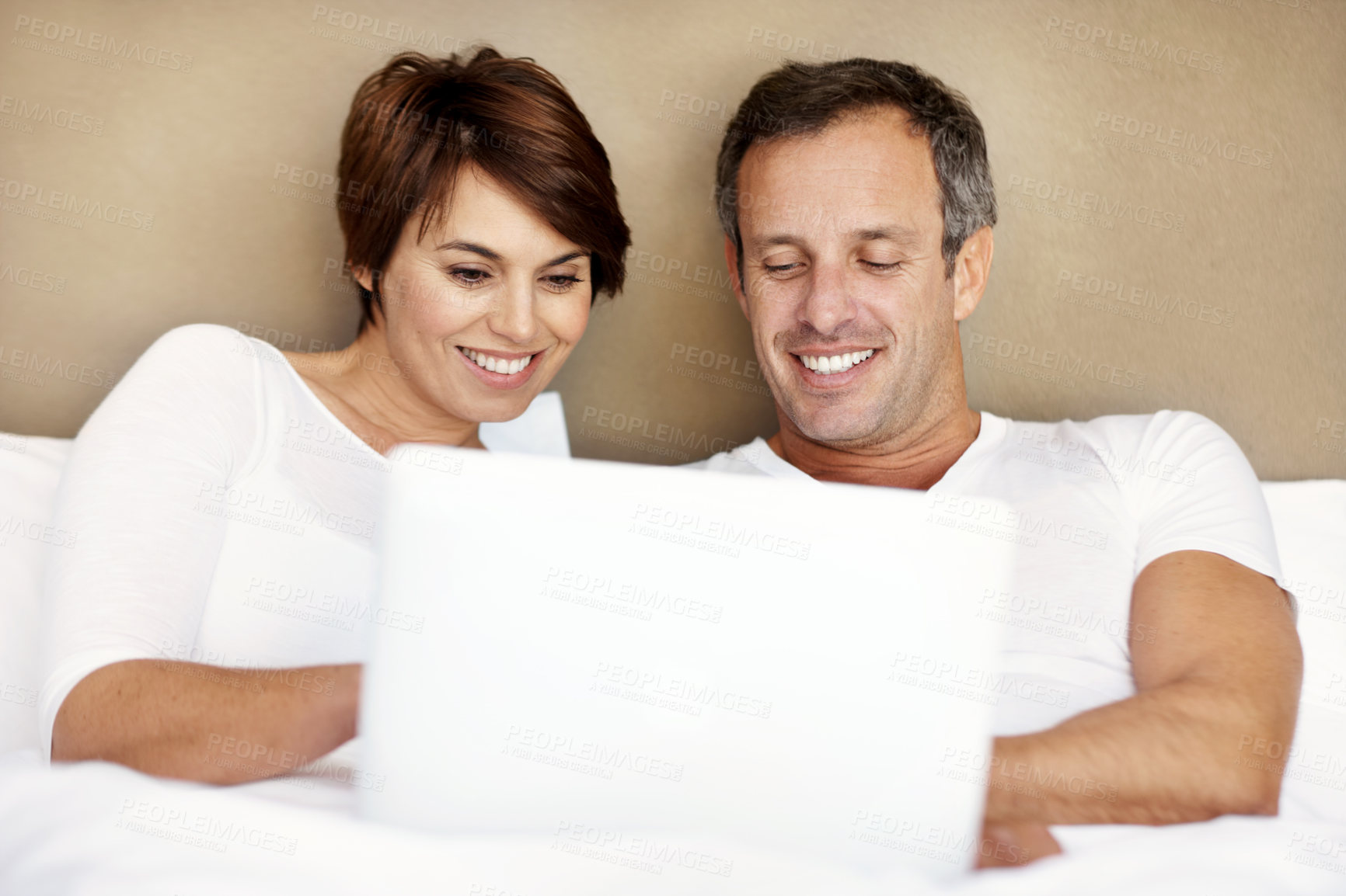 Buy stock photo Morning, laptop and happy couple relax on bed with love, care and bonding with comfort in home. Man, woman and technology in house bedroom with internet connection, streaming online and subscription