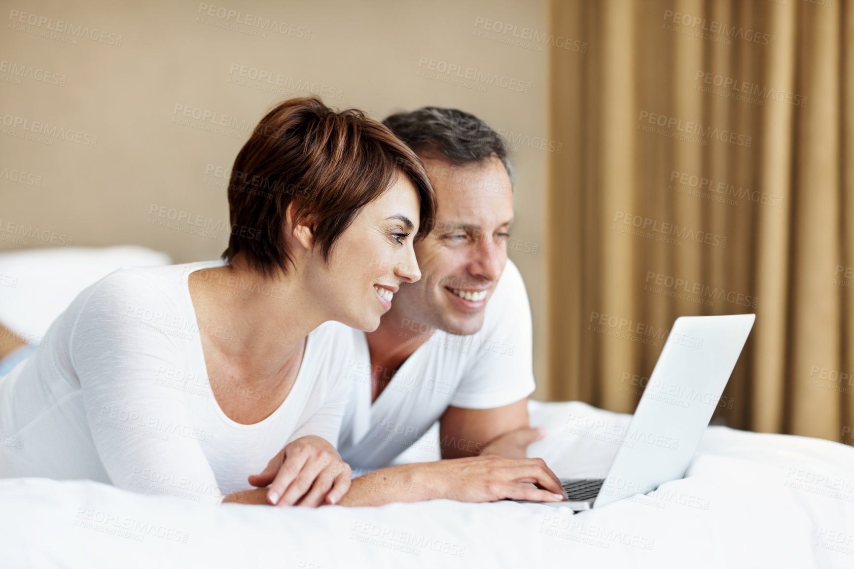 Buy stock photo Happy, laptop and couple together on bed with love, care and bonding with comfort and web in home. Man, woman and tech in bedroom with internet connection, streaming online and movie subscription