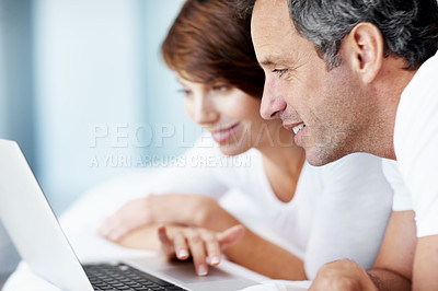 Buy stock photo Happy, laptop and couple together on bed with love, care and bonding with comfort and web in home. Mature man, woman and tech in bedroom with internet connection, streaming online and subscription