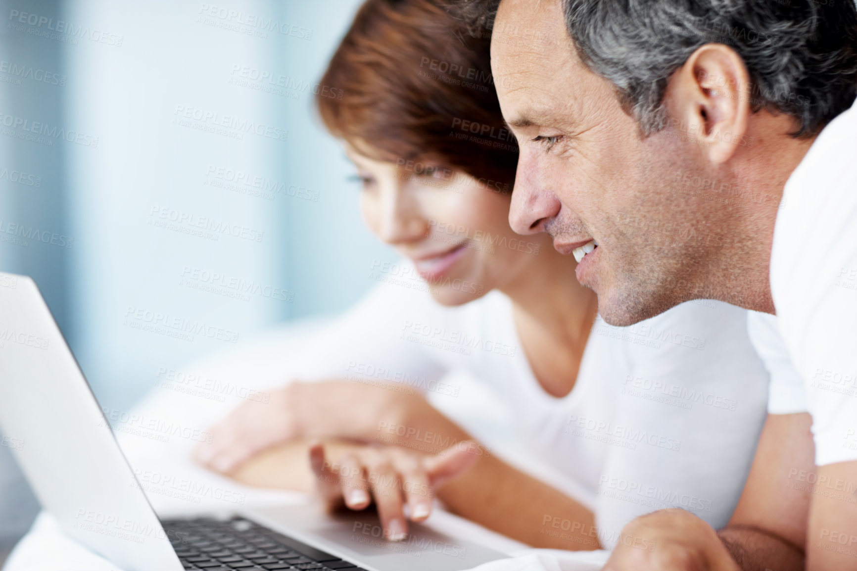 Buy stock photo Happy, laptop and couple together on bed with love, care and bonding with comfort and web in home. Mature man, woman and tech in bedroom with internet connection, streaming online and subscription