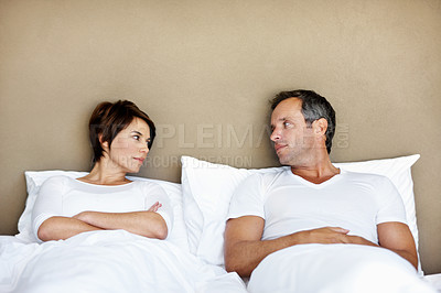 Buy stock photo Couple, serious and upset in bed in home, disagreement or conflict with mistake or fail in relationship. Man, woman and problem in marriage with issues, bedroom trouble or risk of divorce with crisis