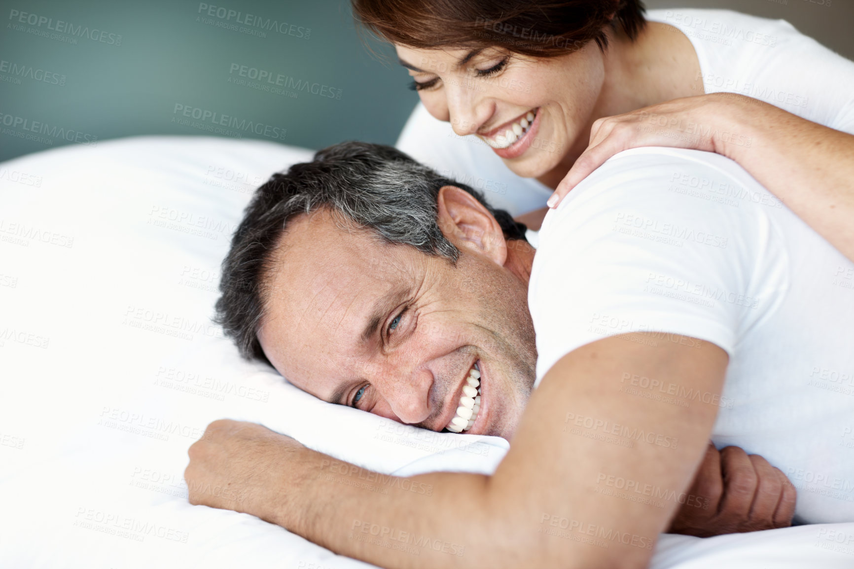 Buy stock photo Love, relax and laugh with couple in bedroom in home for wake up, connection and romantic partner. Bonding, support and morning with mature man and woman in bed in apartment for joke and care