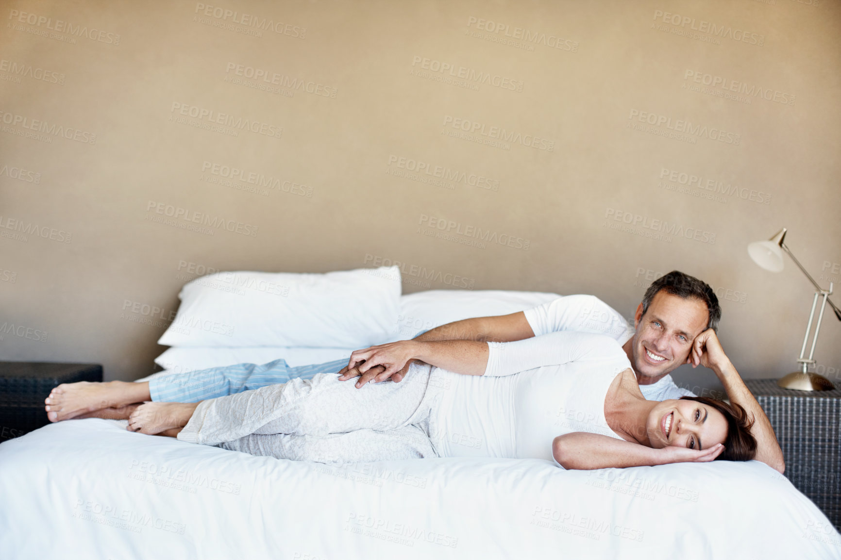 Buy stock photo Morning, portrait and happy couple relax on bed with love, care and bonding with comfort in home. Man, woman and smile in house bedroom with connection, holding hands or partner with space in pyjamas