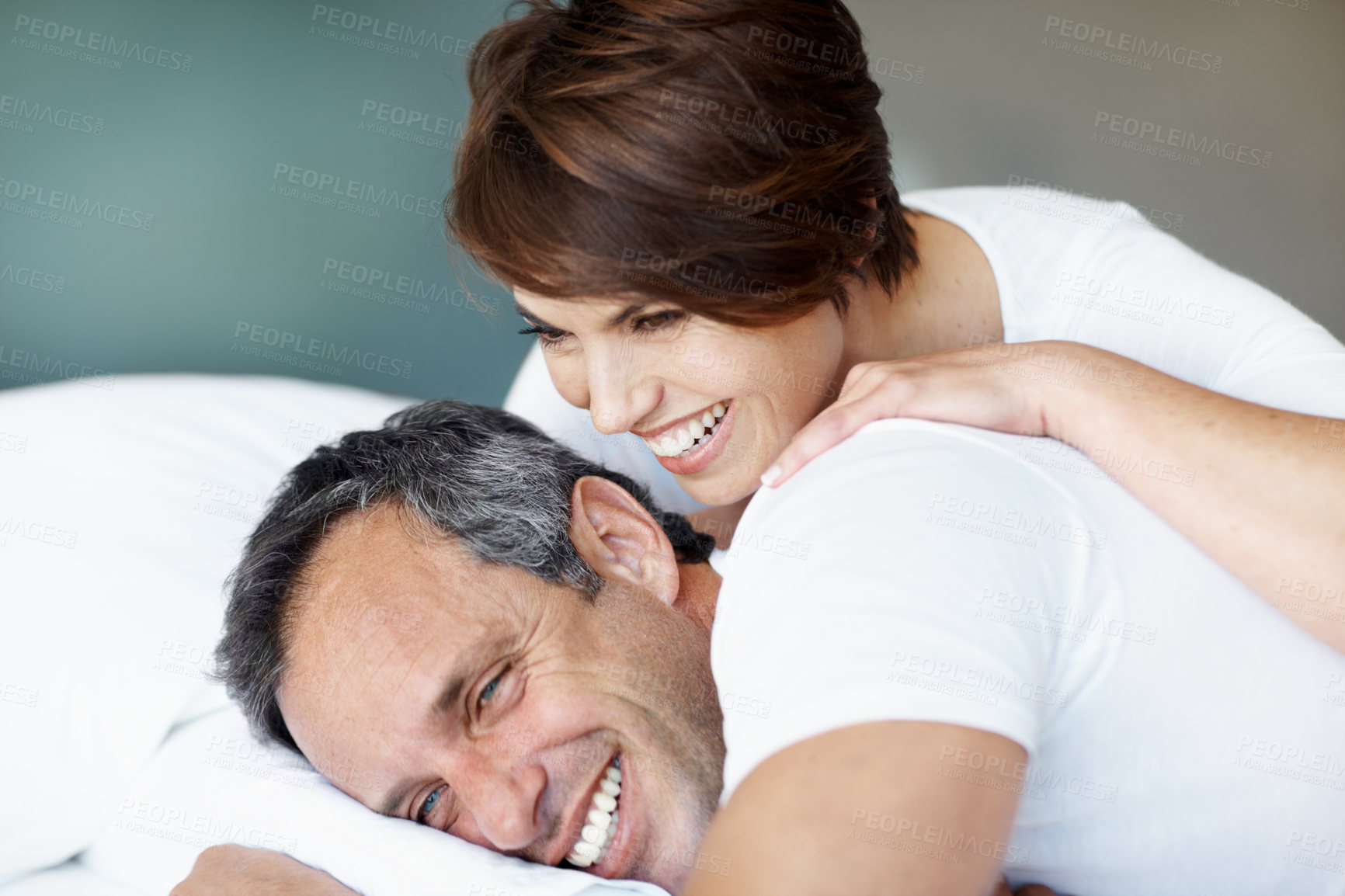 Buy stock photo Laugh, morning and relax with couple in bedroom for romance, valentines day and marriage support. Joke, getaway and care with man and woman in home or staycation for anniversary retreat and love