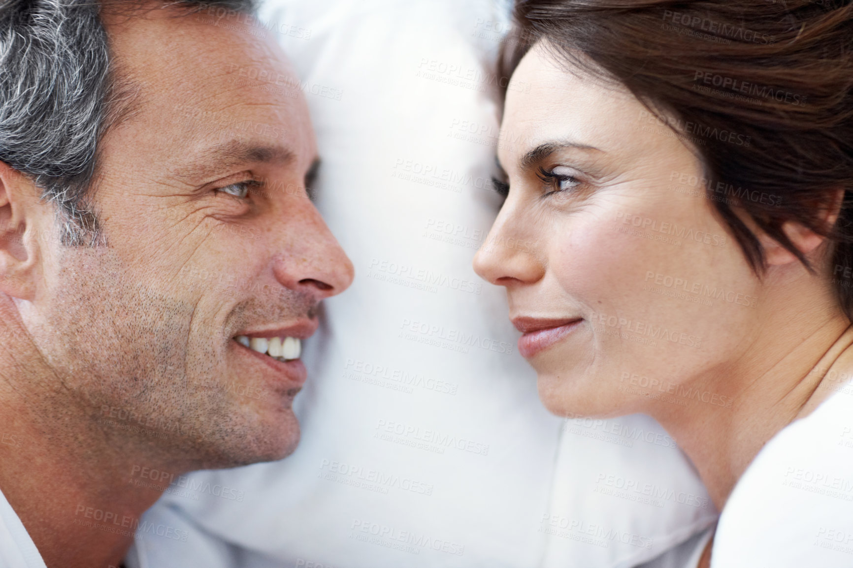 Buy stock photo Love, relax and smile with couple in bedroom in home for wake up, connection and romantic partner. Bonding, support and morning with mature man and woman in bed in apartment for trust and care