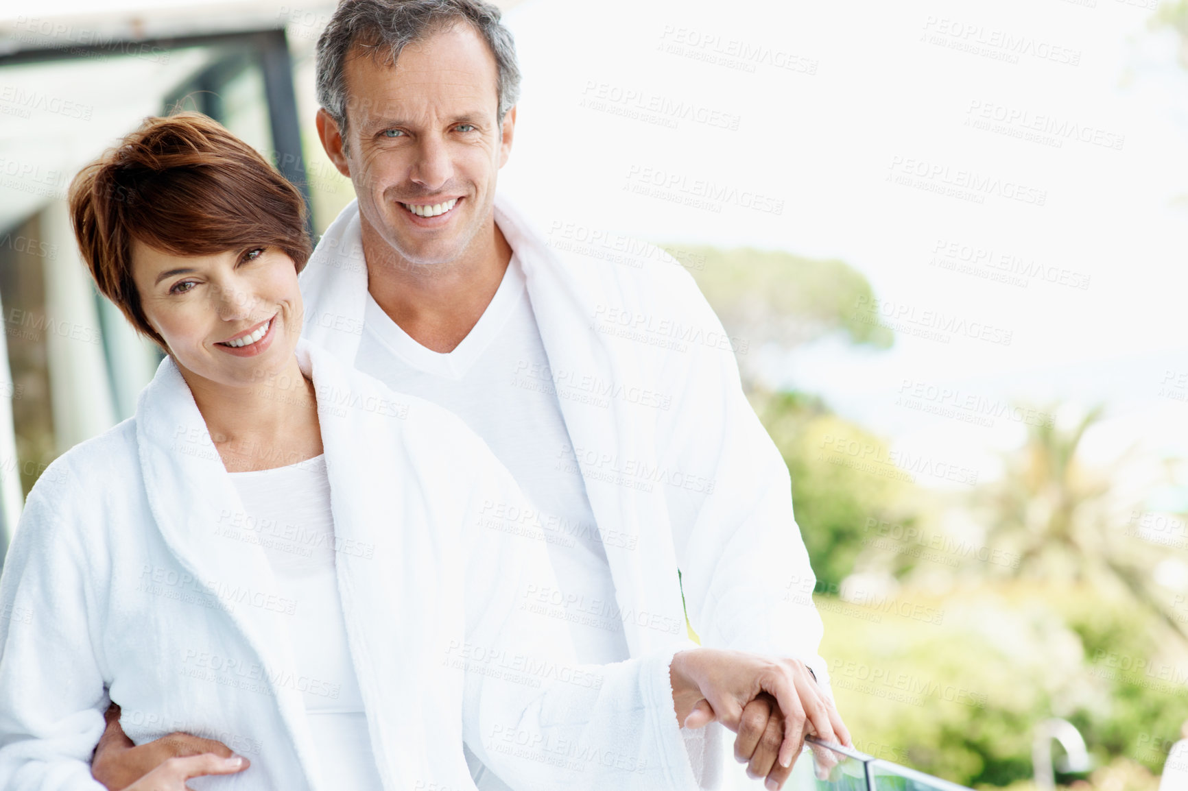 Buy stock photo Smile, couple and relax on balcony with love, affection and bonding together at holiday resort. Portrait, people and terrace at hotel with embrace, healthy relationship and commitment for vacation