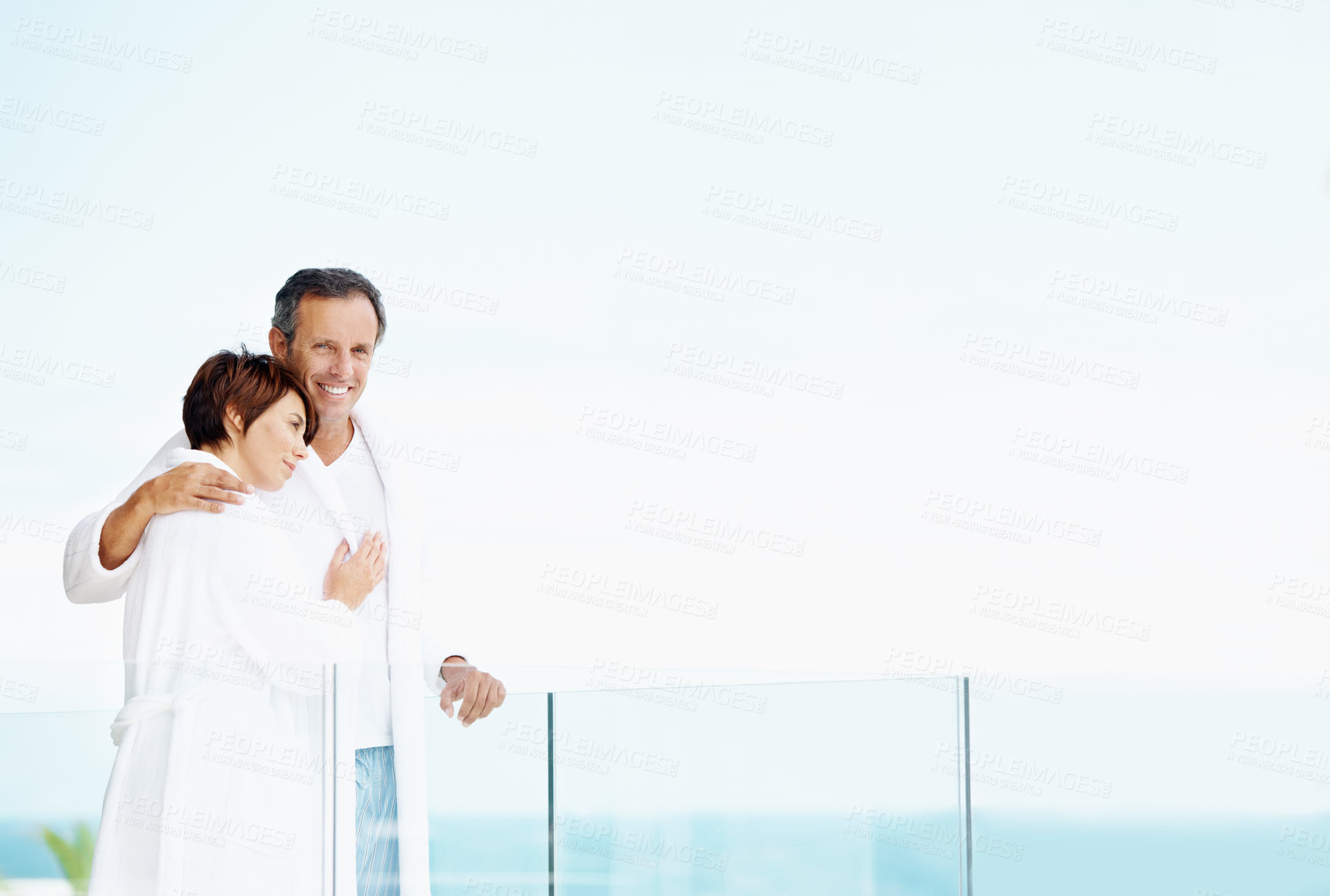 Buy stock photo Smile, couple and love on balcony with hug, affection and bonding together at holiday resort. Portrait, people and terrace with space for fresh air, healthy relationship and commitment for vacation