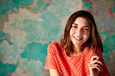Buy stock photo Portrait of a young woman posing in front of a colorful wall