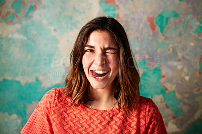 Buy stock photo Portrait of a young woman pulling a face in front of a colorful wall