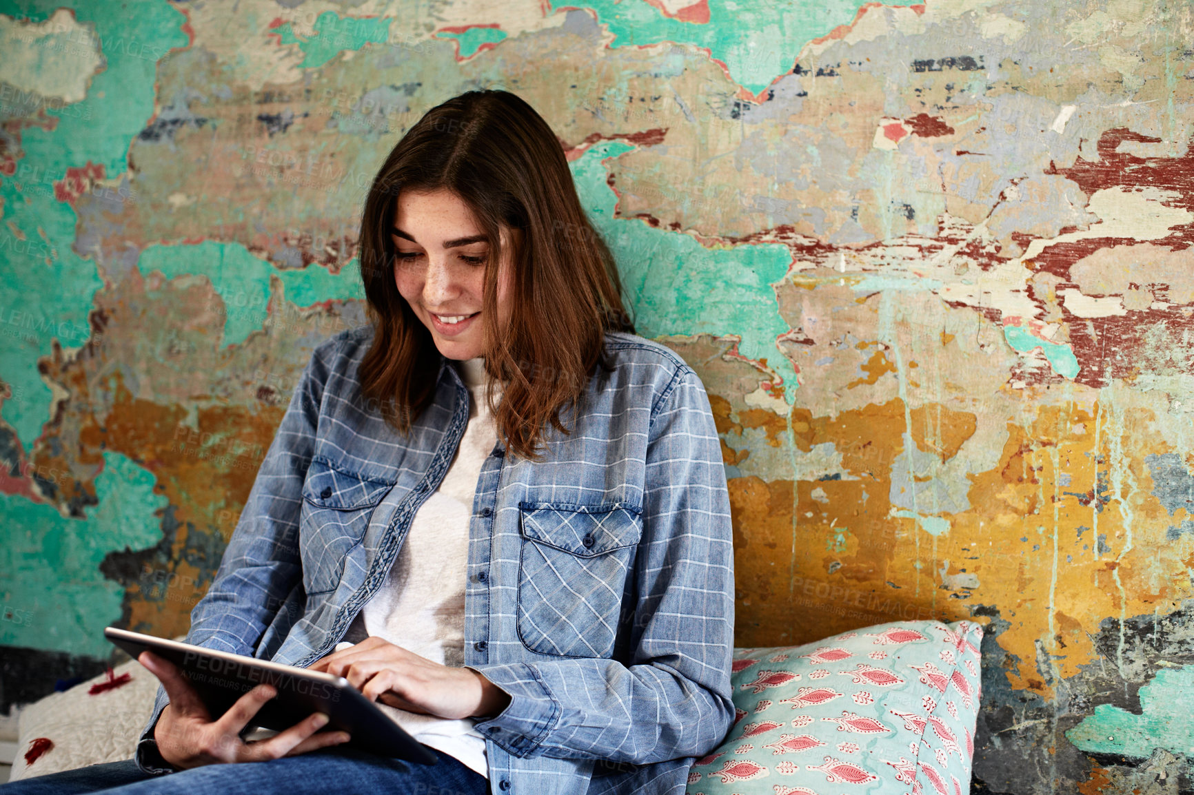 Buy stock photo Shot of a young woman using a digital tablet on the floor indoors