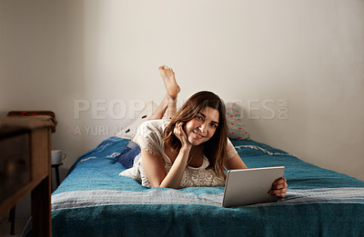 Buy stock photo Portrait of a young woman relaxing with a digital tablet on her bed