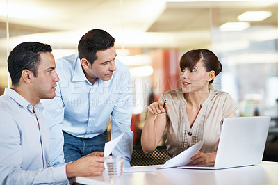 Buy stock photo Shot of coworkers using a laptop at a table in an office