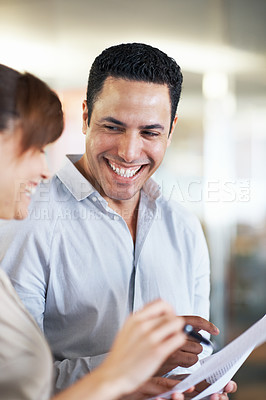 Buy stock photo Shot of two colleagues discussing paperwork while standing in an office