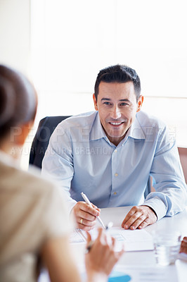 Buy stock photo Shot of two businesspeople talking together at a table in an office