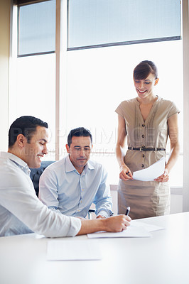 Buy stock photo Shot of coworkers discussing paperwork around a table in an office