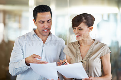 Buy stock photo Shot of two colleagues discussing paperwork in an office