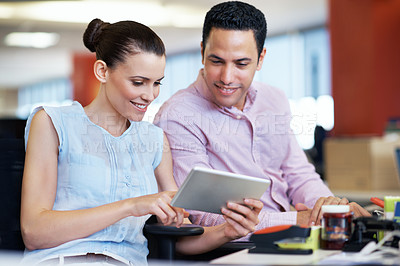 Buy stock photo Shot of two business colleagues discussing work on a digital tablet in an office