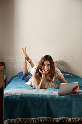 Buy stock photo Portrait of a young woman relaxing with a digital tablet on her bed