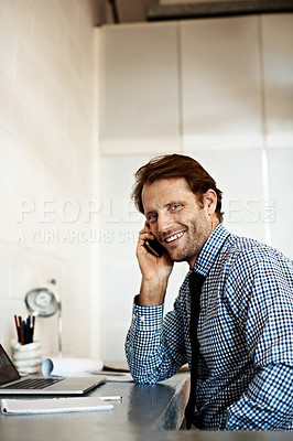 Buy stock photo Shot of a businessman sitting at his desk talking on a cellphone