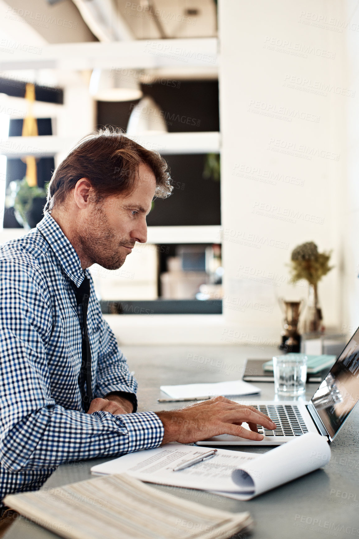 Buy stock photo Shot of a businessman working on a laptop at his desk in an office