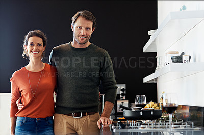 Buy stock photo Portrait of a smiling mature couple standing in their kitchen