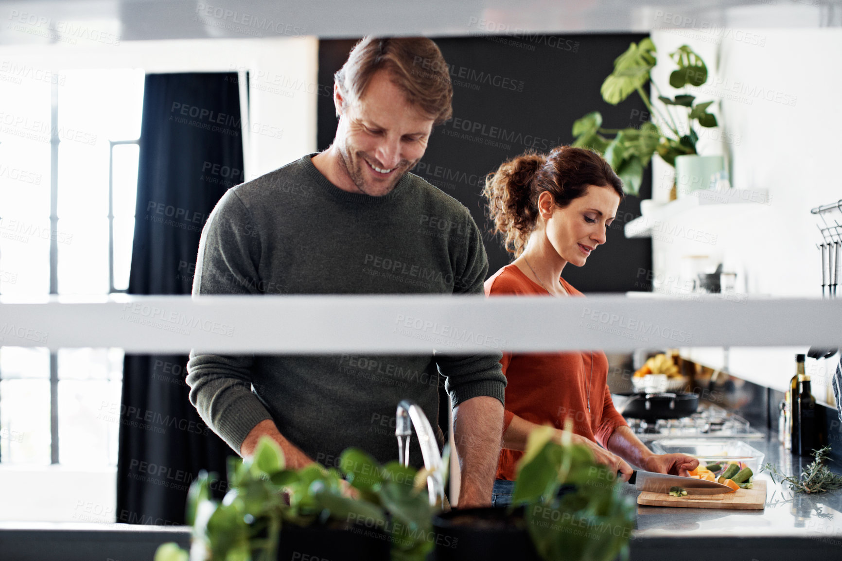Buy stock photo Couple, cooking and smile with recipe in kitchen for love, nutrition or together for dinner. Happy man, woman and support with fresh herbs, ingredients or food with conversation for meal prep in home
