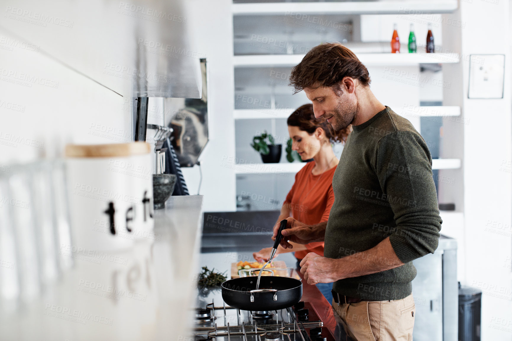 Buy stock photo Shot of a smiling mature couple cooking together in their kitchen